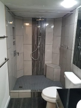 Walk in shower with custom bench, niche, and safety grab bar.